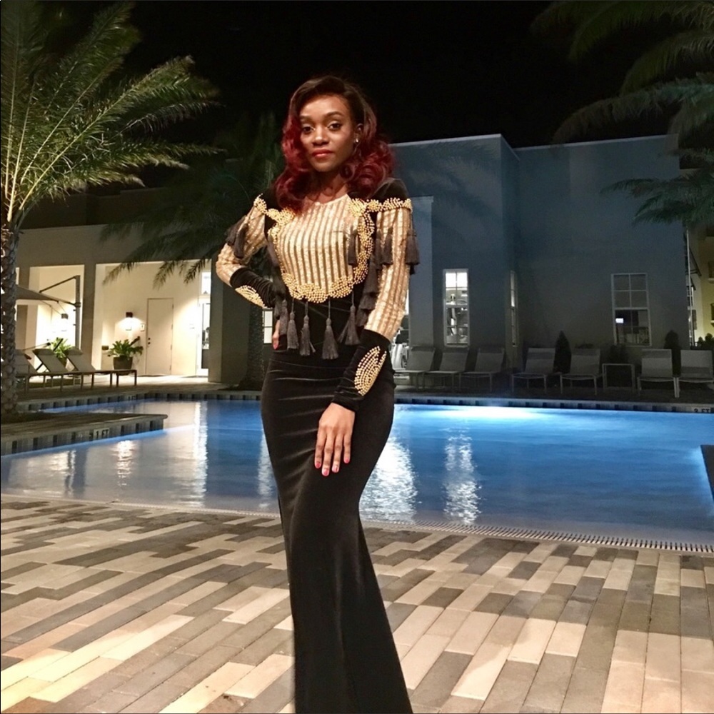 Black and gold gown, long sleeves with tassels.